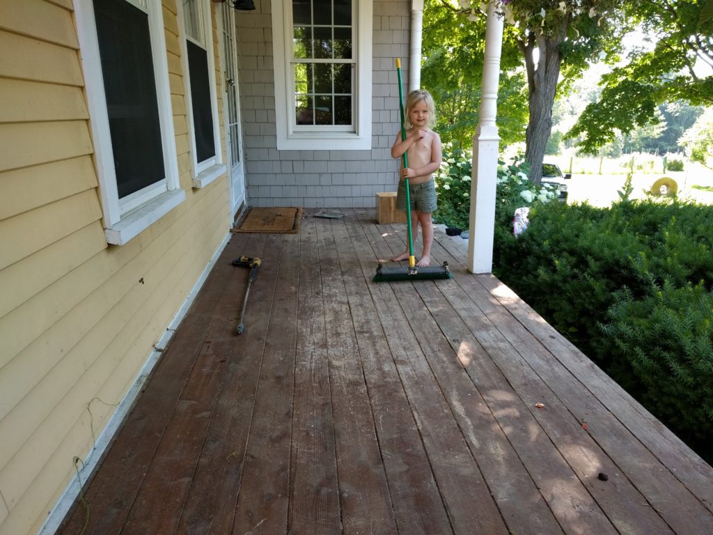 The family helps clean the deck before refinishing.